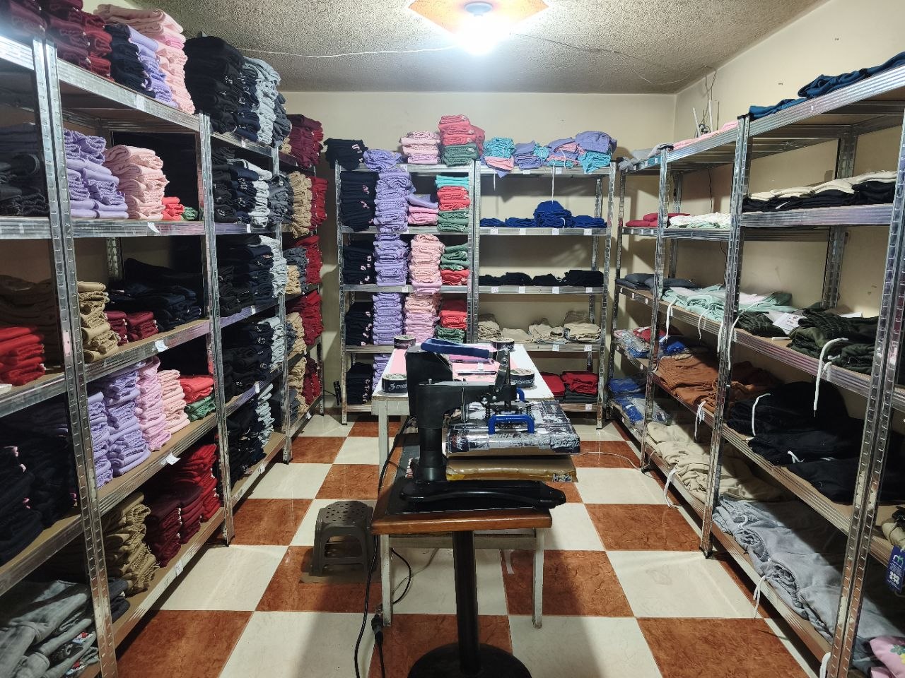 La bodega actual de John: estantería completa llena de ropa infantil organizada
